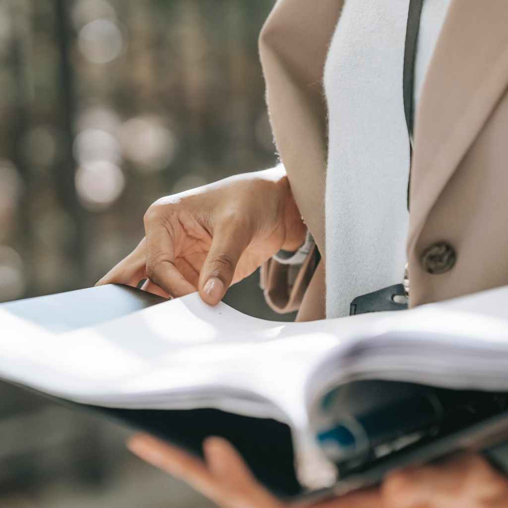 crop businesswoman looking through documents
