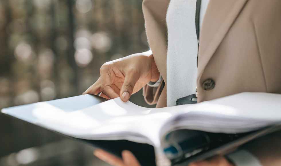 crop businesswoman looking through documents